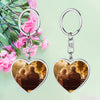 Heart-shaped keychains with an image of an elderly couple on a bench, surrounded by pink flowers.