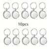Set of 10 silver keychains with blank white round faces on a white background